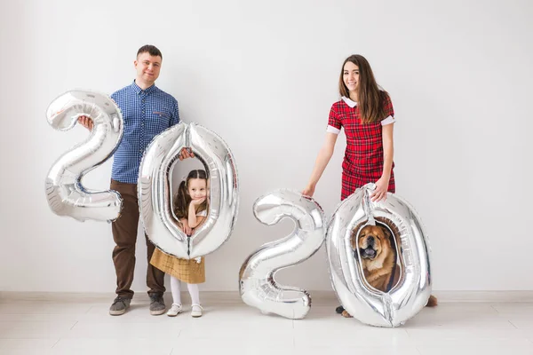 Nuevo 2020 Año viene concepto - Familia feliz con perro están sosteniendo números de color plata en el interior . — Foto de Stock