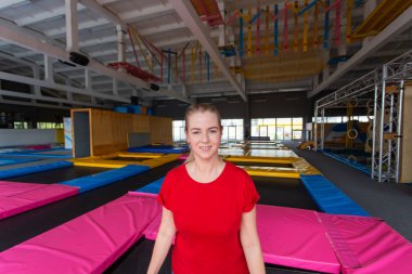 Fitness, eğlence, eğlence ve spor aktivite konsepti - Genç mutlu kadın kapalı bir trambolin üzerinde atlama