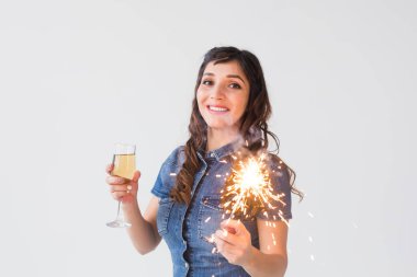 People, celebration and holiday concept - Lovely woman with sparkler and glass of champagne over white background