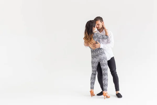 Jeune couple dansant danse latine bachata, merengue, salsa, kizomba. Deux pose d'élégance sur fond blanc avec espace de copie — Photo