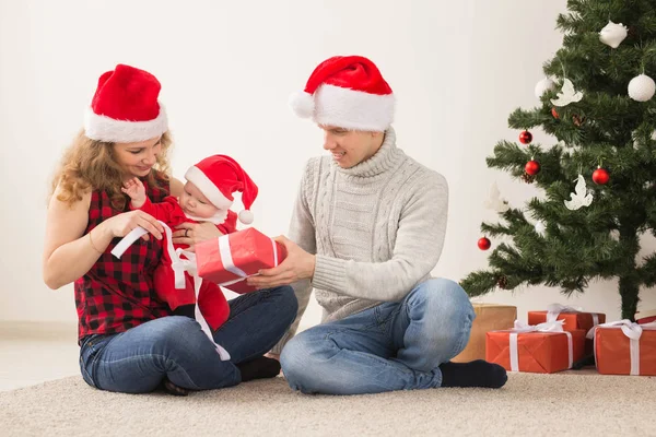 休日、子供と家族のコンセプト-自宅で一緒にクリスマスを祝う赤ちゃんを持つ幸せなカップル. — ストック写真