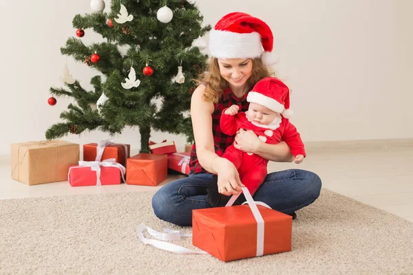 Rodinný, dětský a vánoční koncept - Portrét šťastné matky a roztomilého miminka v obleku Santy — Stock fotografie