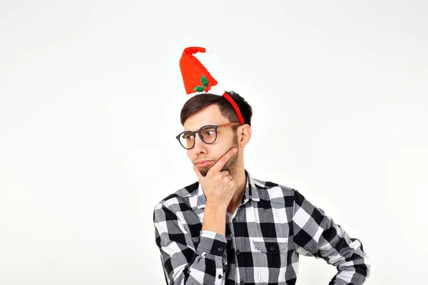 Retrato de un joven divertido con sombrero y barba de Santa Claus sobre fondo blanco. Navidad . —  Fotos de Stock