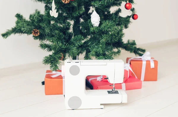 Праздники, дизайн одежды и подарочная концепция - Швейная машина в подарок под елкой — стоковое фото