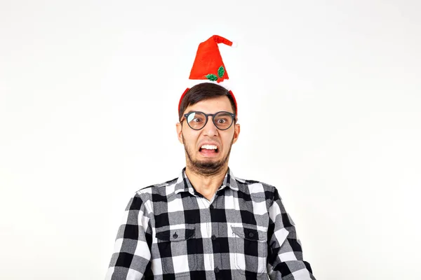 Vacaciones y presenta concepto - Divertido hombre emocional en sombrero de Navidad sobre fondo blanco con copyspace —  Fotos de Stock