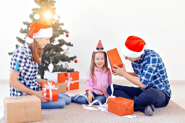 Рождество и праздничная концепция - Открытие рождественских подарков перед елкой — стоковое фото