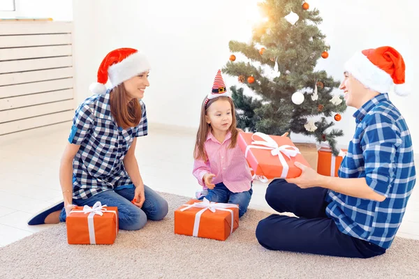 休日とプレゼントのコンセプト – クリスマス時に幸せな家族のオープニングギフトの肖像画 — ストック写真