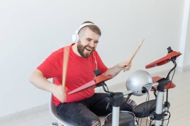 Müzik, hobi ve insan kavramı - genç adam davulcu elektronik davul çalıyor