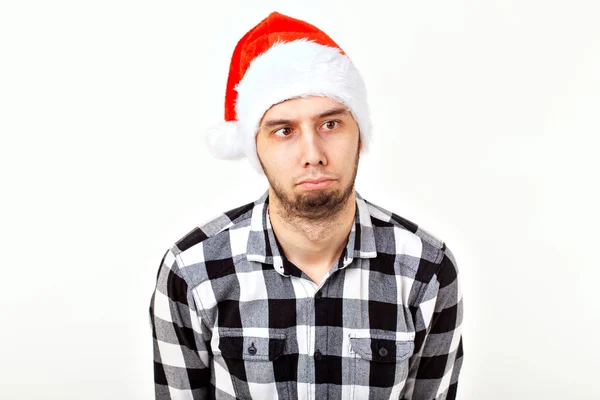 Boże Narodzenie, ferie zimowe i koncepcja ludzi - zabawny człowiek w kapeluszu Świętego Mikołaja na białym tle — Zdjęcie stockowe