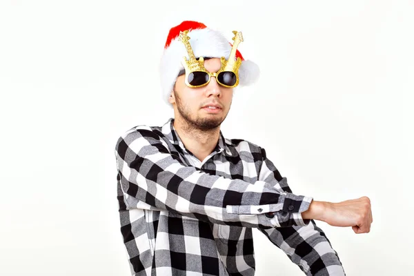 Porträtt av en rolig ung man i jultomten hatt och skägg på vit bakgrund. Julen. — Stockfoto