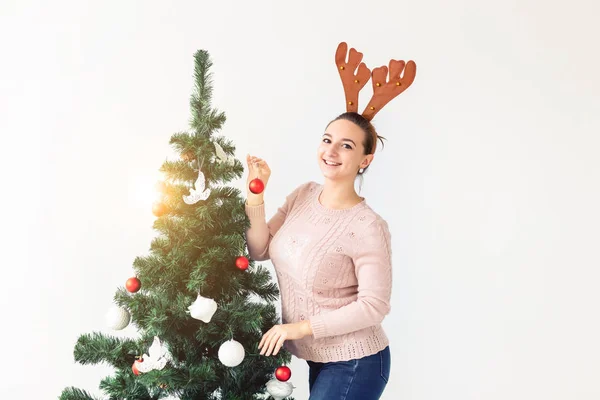 Holidays concept - Funny young woman decorated christmas tree on white background with copy space. Waiting for christmas. — Stok fotoğraf