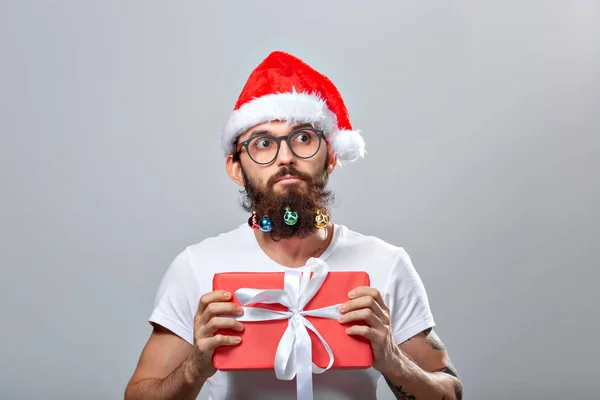 Christmas, holidays, barbershop and style concept - young handsome bearded santa claus man with many small christmas baubles in long beard — Stockfoto