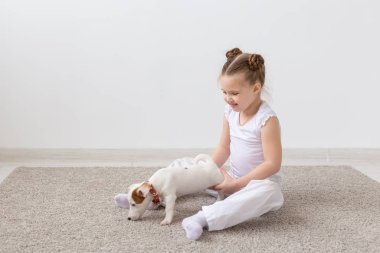 Evde beslenen hayvan, çocuk ve hayvan kavram - bir köpek yavrusu pençe tarafından tutan kız çocuk