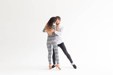 Genç çift dans sosyal Latin dans Bachata, Merengue, salsa. Kopya alanı ile beyaz arka planda iki zarafet poz