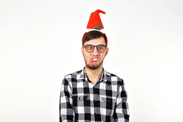Портрет смешного молодого человека в шляпе Санта-Клауса и бороде на белом фоне. Рождество . — стоковое фото