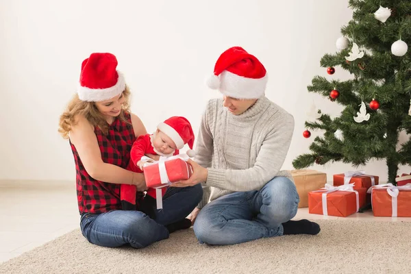 Coppia felice con bambino che festeggia il Natale insieme a casa . — Foto Stock