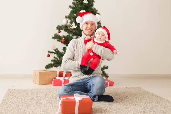 Ojciec z jego chłopca, noszenie czapki Santa na święta. — Zdjęcie stockowe