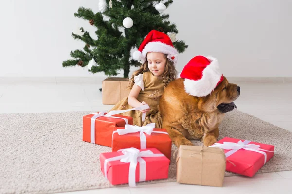 Kinder-und Haustier-Konzept - niedliches Mädchen mit Chow-Hund sitzt neben dem Weihnachtsbaum. Frohe Weihnachten und frohe Feiertage. — Stockfoto