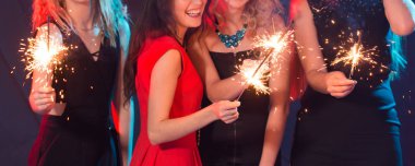 Doğum günü partisi, yeni yıl ve tatil konsepti - bir grup bayan arkadaş havai fişek tutmasını kutluyor, yakın plan.