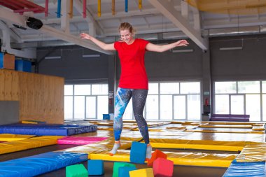 Fitness, eğlence, eğlence ve spor aktivite konsepti - Genç mutlu kadın kapalı bir trambolin üzerinde atlama