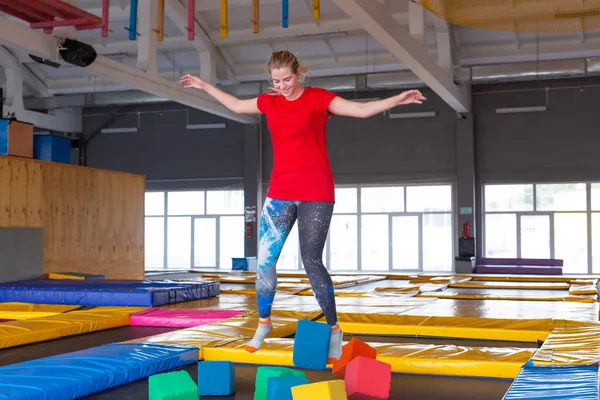 Fitness, eğlence, eğlence ve spor aktivite konsepti - Genç mutlu kadın kapalı bir trambolin üzerinde atlama
