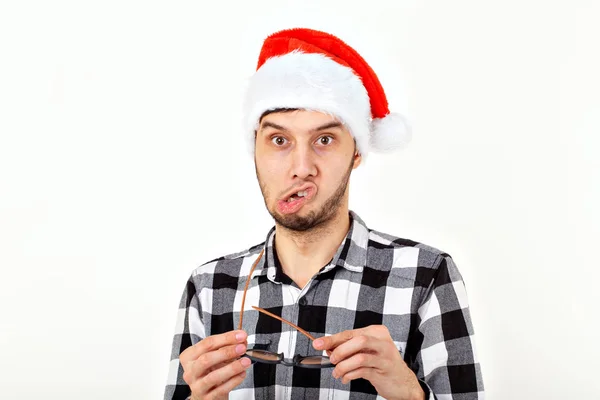 サンタクロースの帽子と白い背景にひげの面白い若い男の肖像画。クリスマス. — ストック写真