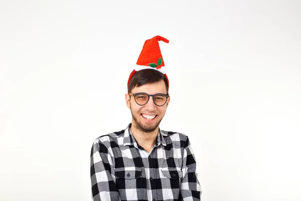 Retrato de um jovem engraçado em chapéu de Papai Noel e barba em fundo branco. Natal. . — Fotografia de Stock