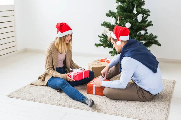 休日、家族やお祝いのコンセプト-自宅でクリスマスの贈り物を持つカップル — ストック写真