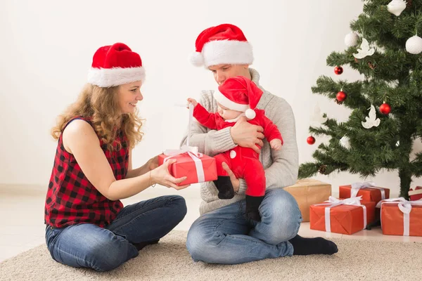 Glückliches Paar mit Baby feiert Weihnachten gemeinsam zu Hause. — Stockfoto