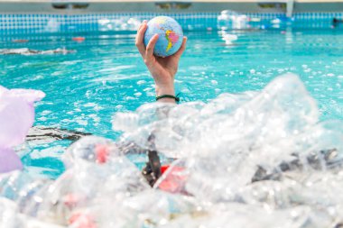 Ufa, Rusya - 25 Temmuz 2019 : Çöp sorunu, plastik geri dönüşüm, kirlilik ve çevre kavramı - Su ortamında plastik çöp kirliliği, Dünya küre çöp içinde yüzen