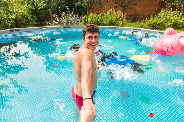 Ecologie, plastic afval, milieu nood en watervervuiling-Guy leiden in een zwembad met vuilnis — Stockfoto