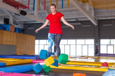 Fitness, eğlence, eğlence ve spor aktivite konsepti - Genç mutlu kadın kapalı bir trambolin üzerinde atlama
