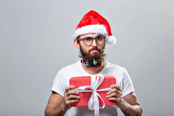 Christmas, holidays, barbershop and style concept - young handsome bearded santa claus man with many small christmas baubles in long beard — Stockfoto