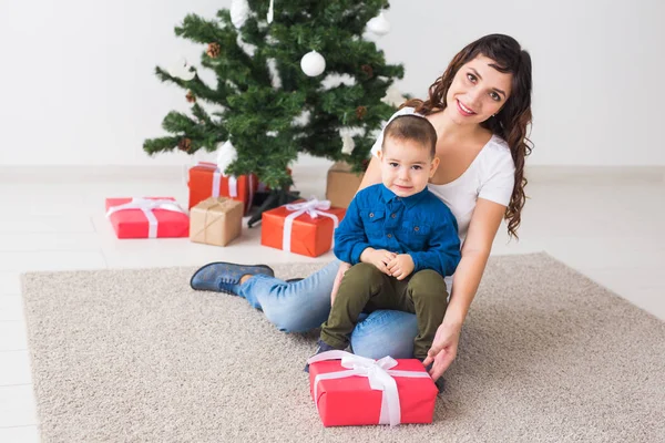 Χριστούγεννα, μόνος γονέας και έννοια των διακοπών - χαριτωμένο μικρό αγόρι κρατώντας χριστουγεννιάτικο δώρο για τη μητέρα του στο σπίτι. — Φωτογραφία Αρχείου