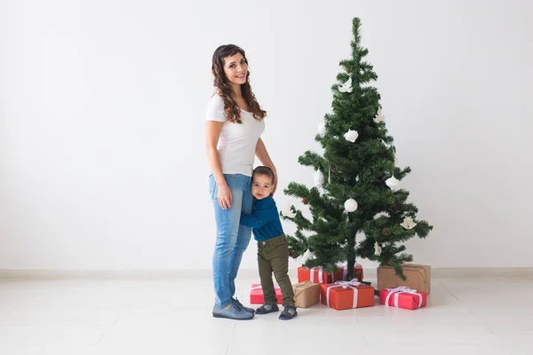 Vánoce, svobodný rodič a svátky koncept - Roztomilý chlapeček a jeho matka stojí u vánočního stromečku — Stock fotografie