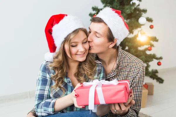 Family, x-mas, winter holidays and people concept - happy couple hugging near christmas tree at home Royalty Free Stock Photos