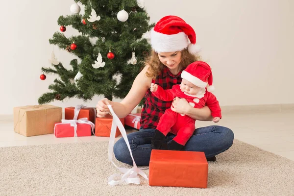 Rodinný, dětský a vánoční koncept - Portrét šťastné matky a roztomilého miminka v obleku Santy — Stock fotografie