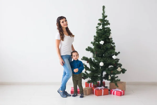 Vánoce, svobodný rodič a svátky koncept - Roztomilý chlapeček a jeho matka stojí u vánočního stromečku — Stock fotografie