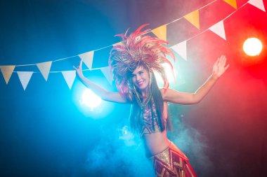 Karnaval, oryantal dans ve tatil konsepti - Altın kostüm giyen ve gülümseyen güzel kadın samba dansçısı