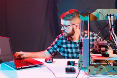 Teknoloji ve mühendislik konsepti - Laboratuvarda gece çalışan erkek mühendis, 3D yazıcı bileşenlerini ayarlıyor.