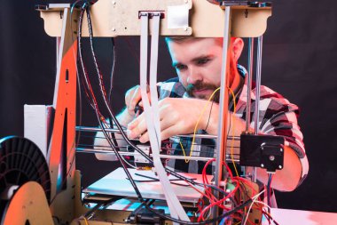 Teknoloji ve mühendislik konsepti - Laboratuvarda gece çalışan erkek mühendis, 3D yazıcı bileşenlerini ayarlıyor.