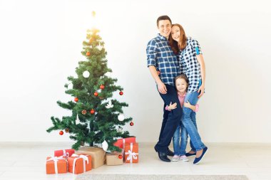 Tatiller ve festival konsepti - Noel ağacıyla mutlu aile portresi