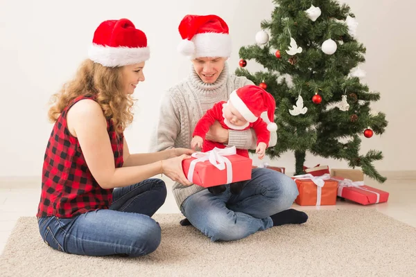 Coppia felice con bambino che festeggia il Natale insieme a casa . — Foto Stock