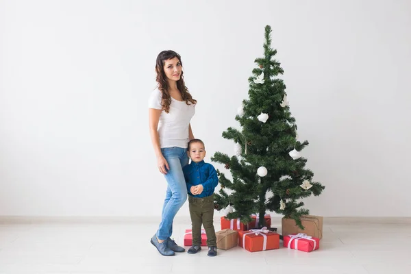 Kerst, alleenstaande ouder en vakantie concept - Leuke kleine jongen en zijn moeder staan in de buurt van kerstboom — Stockfoto