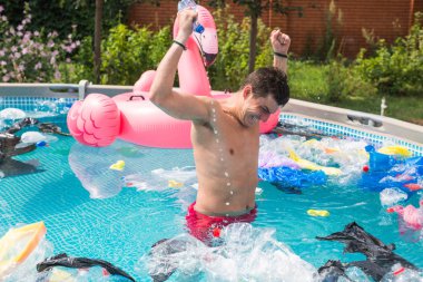 Ekoloji, plastik çöp, çevresel acil durum ve su kirliliği - kirli bir yüzme havuzunda duran şok adam