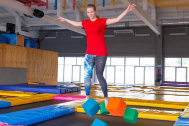 Fitness, eğlence, eğlence ve spor aktivite konsepti - Genç mutlu kadın kapalı bir trambolin üzerinde atlama