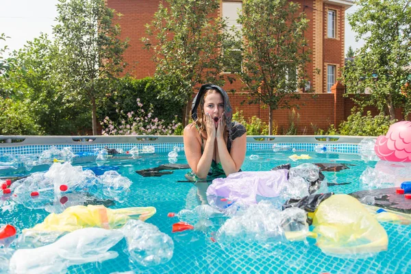 Ecología, basura plástica, emergencia ambiental y contaminación del agua: mujer gritando con una bolsa de plástico sobre su cabeza en una piscina sucia — Foto de Stock