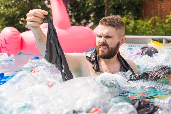 Ecology, plastic trash, environmental emergency and water pollution - shocked man swim in a dirty swimming pool