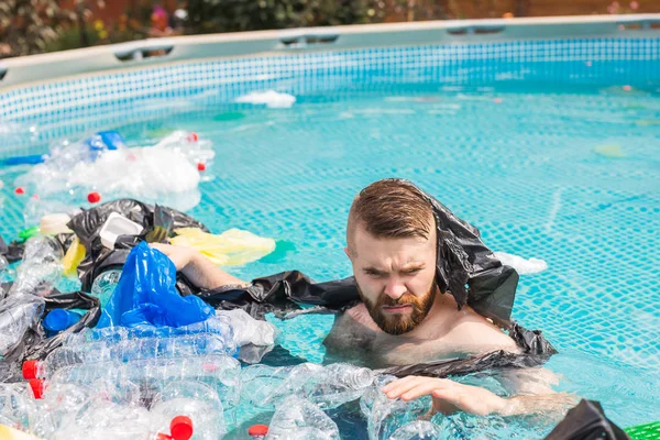 Ecology, plastic trash, environmental emergency and water pollution - shocked man swim in a dirty swimming pool