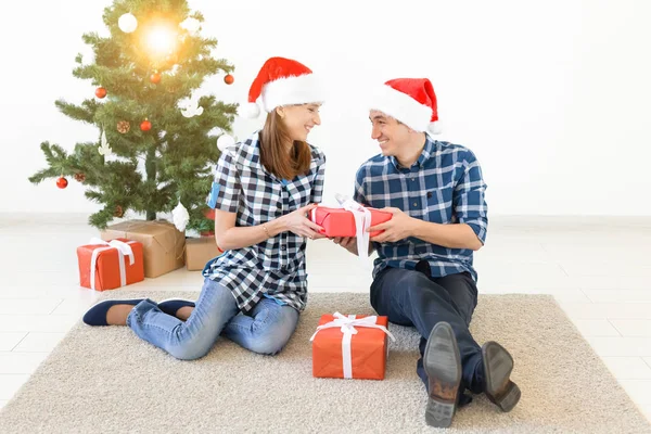休日、クリスマス、家族のコンセプト-自宅で幸せなカップルのオープニングギフト. — ストック写真
